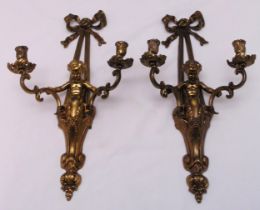 A pair of gilt metal two light wall sconces in the form of putti supporting scroll branches