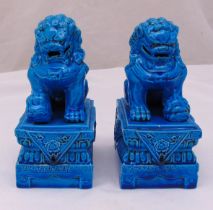 A pair of Chinese turquoise bookends in the form of seated lions on raised rectangular plinths, 21.