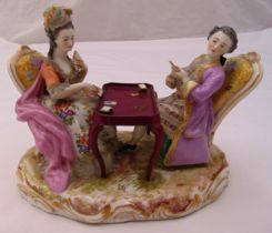 A continental porcelain figural group of a lady and gentleman playing cards on shaped naturalistic