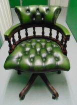 A mahogany and faux leather captains chair on original castors