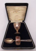 A cased hallmarked silver Christening set to include an egg cup, spoon and a napkin ring