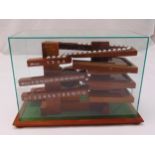 A wooden Rolling Ball mantle clock in fitted glass case to include 30 metal balls