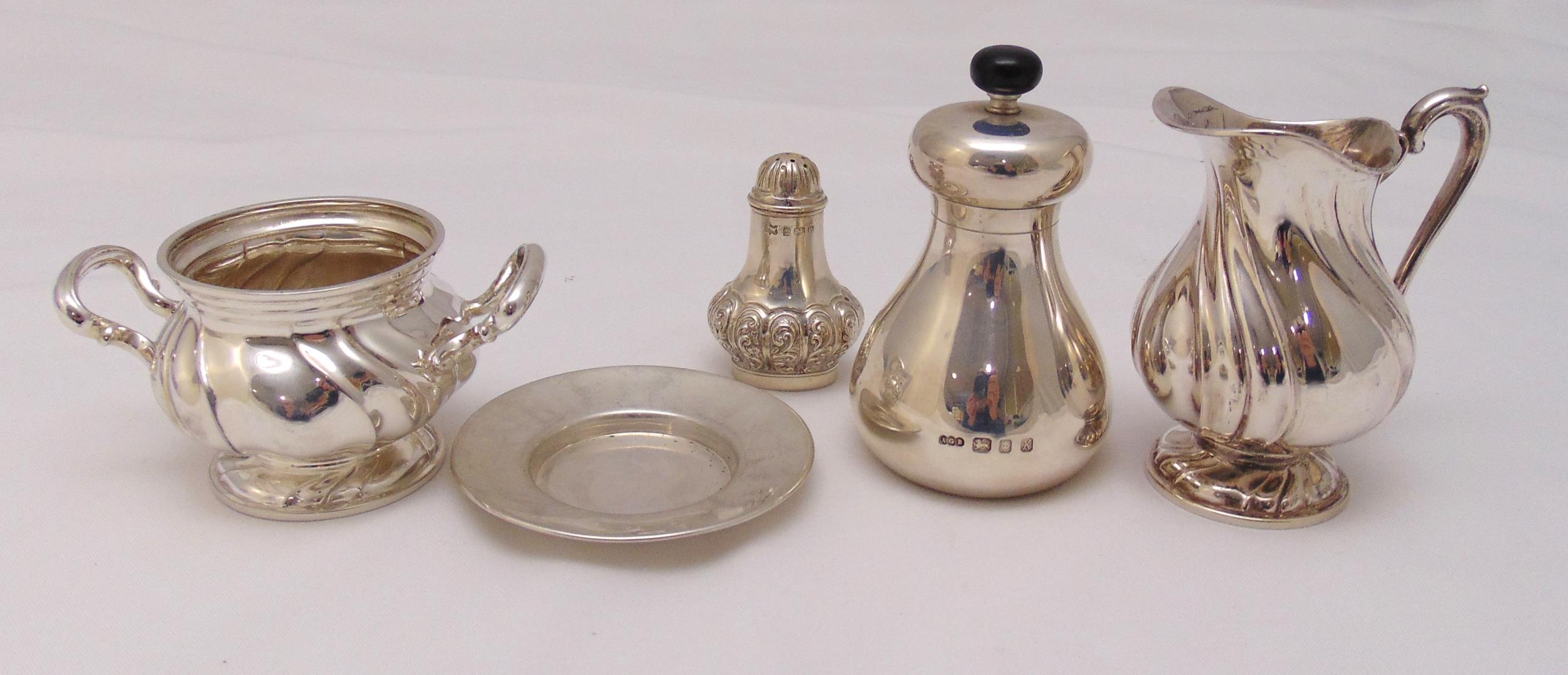 A quantity of hallmarked silver and white metal to include a cream jug, a sugar bowl, a pepper