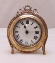 A hallmarked silver desk clock of circular form, white enamel dial with Roman numerals, the silver