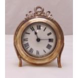 A hallmarked silver desk clock of circular form, white enamel dial with Roman numerals, the silver