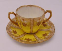 Aynsley cabinet cup and saucer with gilded borders and side handles, marks to the base