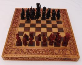 A carved wooden chess set and board