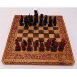 A carved wooden chess set and board