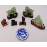 A pair of jadeite dogs of foe on carved wooden stands, a jadeite figurine of a reclining Buddha on a