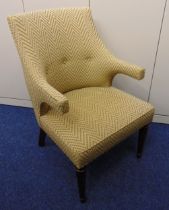 A mid 20th century upholstered armchair on four tapering cylindrical legs