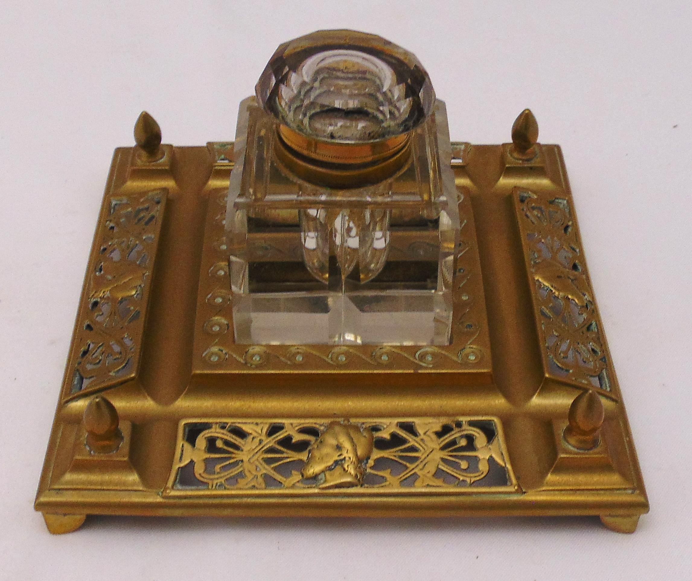 A Victorian cut glass and brass inkwell, the pierced square mount supporting detachable glass