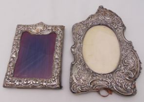 Two hallmarked silver mounted photograph frames, the borders profusely chased with scrolls and