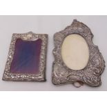 Two hallmarked silver mounted photograph frames, the borders profusely chased with scrolls and