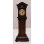 An Edwardian miniature oak cased grandfather clock with flanking brass columns on raised rectangular