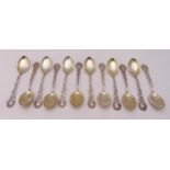 A set of twelve white metal ice cream spoons with scroll chased handles and fluted bowls, stamped