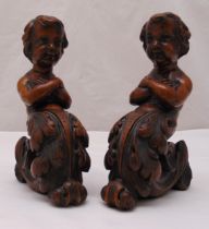 A pair of 19th century carved mahogany finials in the form of putti with acanthus leaves, 27 x 18