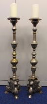 A pair of silvered metal candlesticks of cylindrical knopped form on raised triform bases, 100cm (