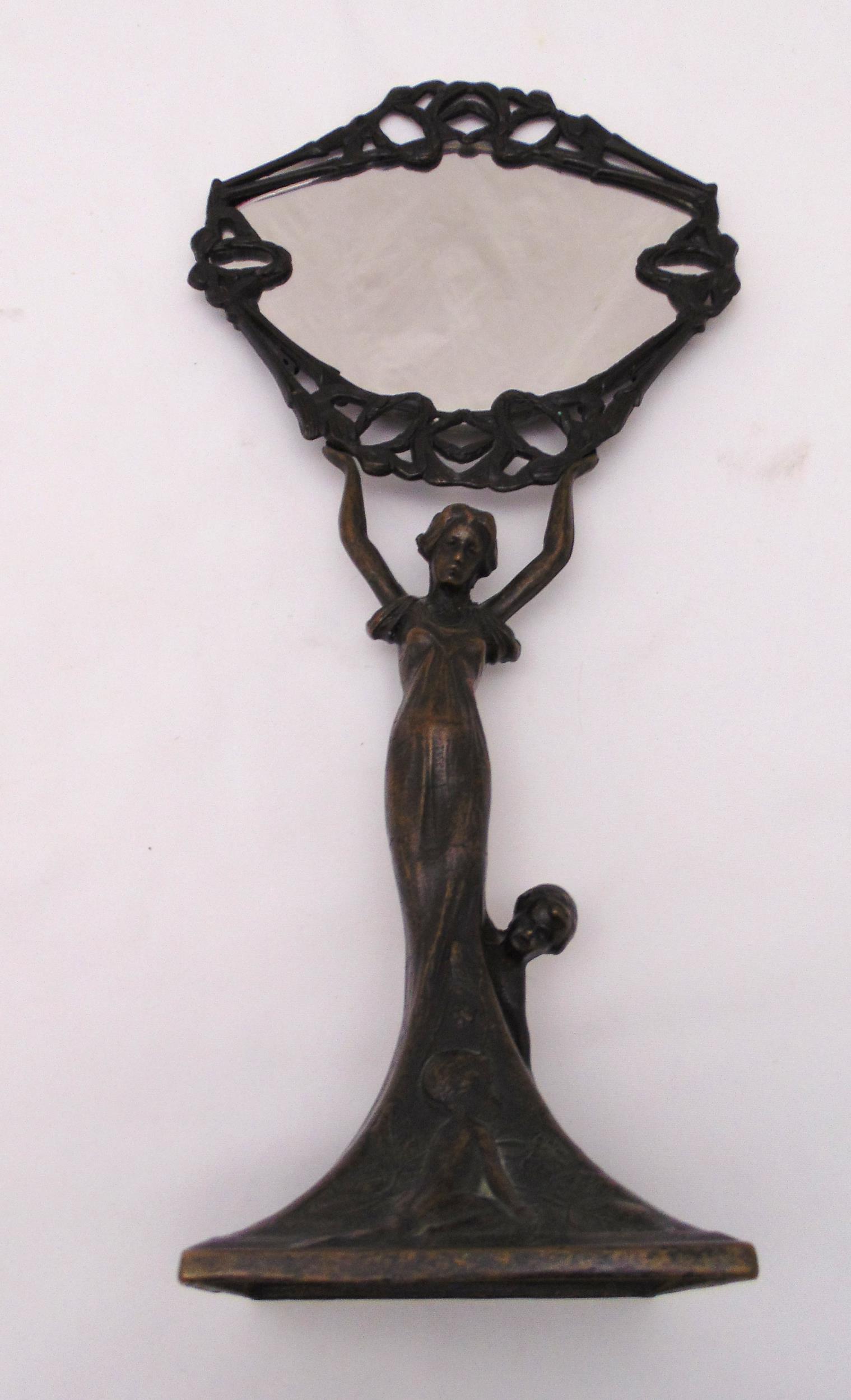 A late 19th century bronze table mirror in the form of a lady with children supporting the oval