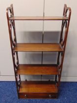 A four tier rectangular mahogany wall shelf with scroll pierced sides and a single drawer, 87.5 x
