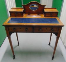 An Edwardian rectangular desk with four drawers and inset tooled leather top on four tapering