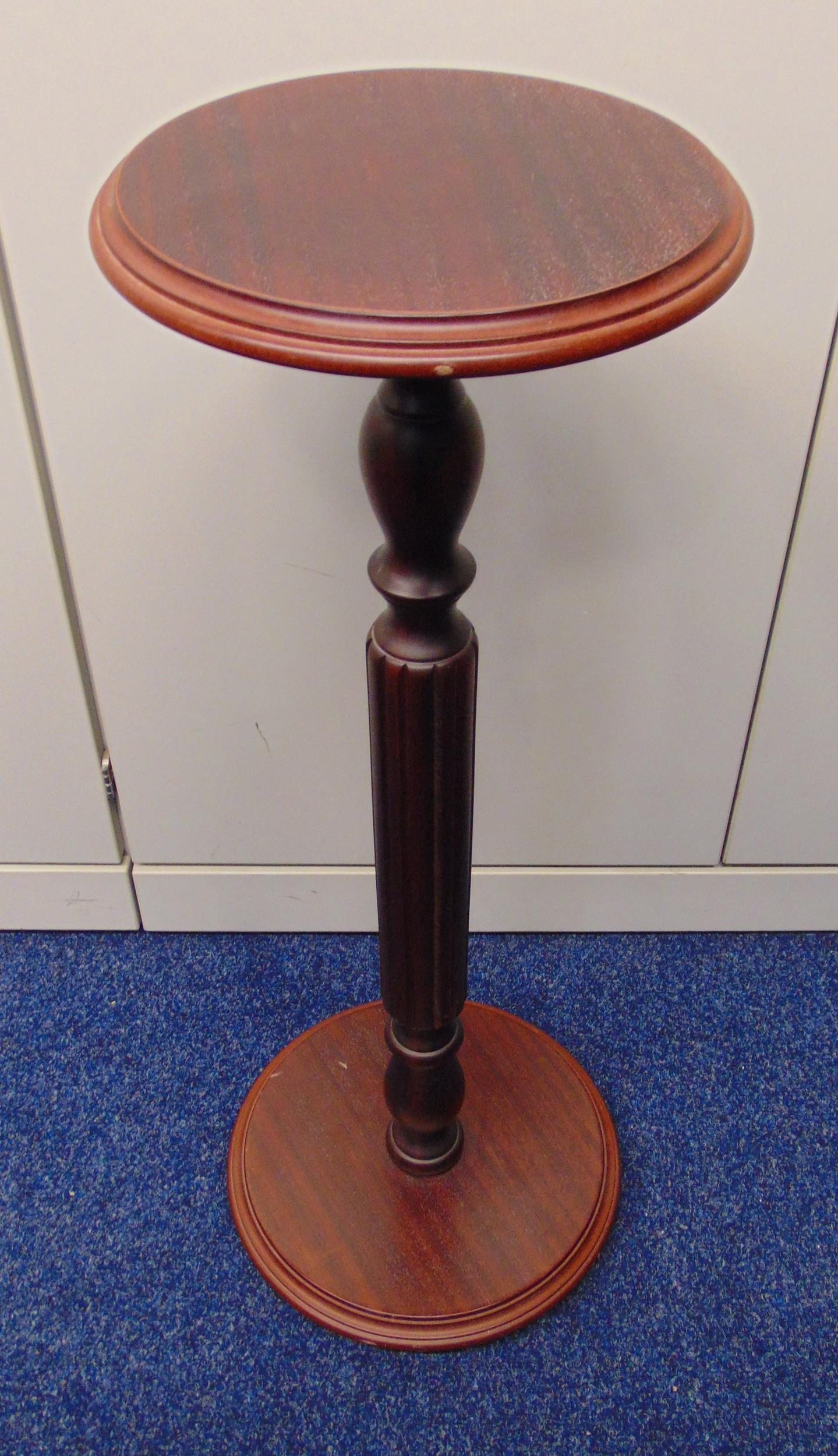 A mahogany circular plant stand on fluted stem and raised circular base, 77 x 26cm