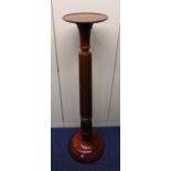 A mahogany torchere plant stand fluted column supporting circular stand on raised circular base, A/