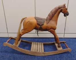 A vintage wooden rocking horse with leather saddle and metal stirrups, 61 x 82 x 27cm