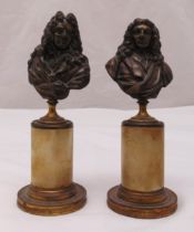 A pair of cast metal busts of gentleman in full bottom wigs on raised cylindrical bases, 21cm (h)