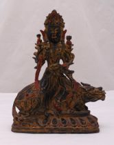 A Tibetan gilded bronze Buddha seated on a Temple lion all on a shaped rectangular raised base, 33cm