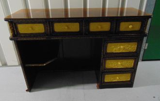 A Chinese rectangular hardwood kneehole desk with seven drawers decorated with painted panels, the