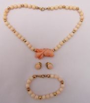 A gold and coral necklace with matching bracelet and a pair of earrings