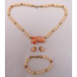 A gold and coral necklace with matching bracelet and a pair of earrings