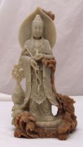 A Chinese soapstone figurine of a Deity flanked by a dragon and a fish on naturalistic base, 53.