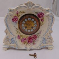 A continental porcelain mantle clock with circular dial and Roman numerals the case decorated with