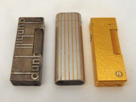 Two Dunhill cigarette lighters and a Cartier cigarette lighter