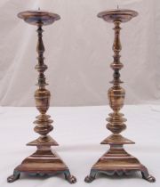 A pair of silver plated pricket candlesticks with knopped stems on tri-form bases with claw feet,