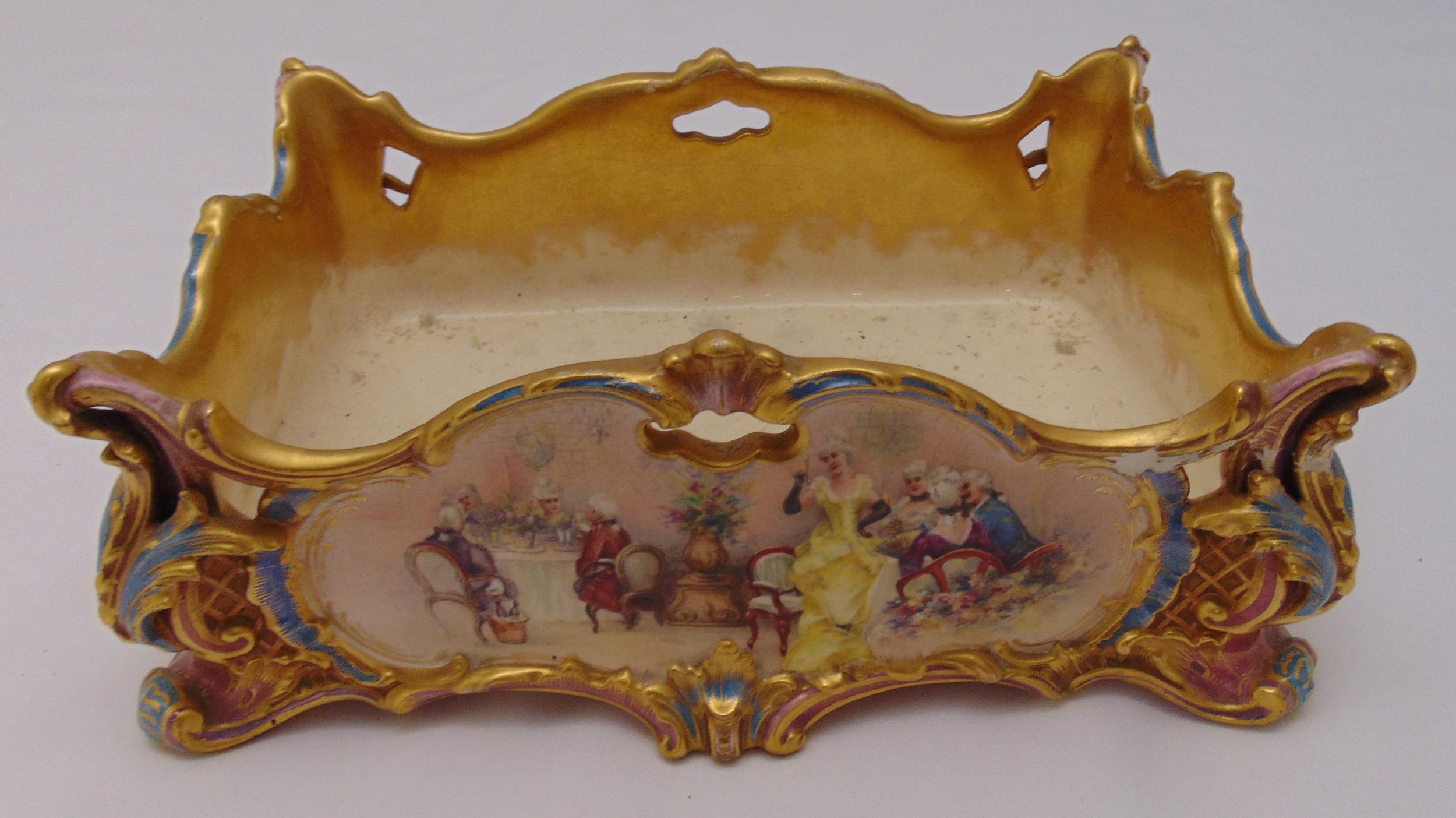 A continental rectangular ceramic planter decorated with figures in a landscape and gilded