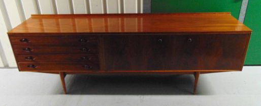 A mid 20th century rectangular teak sideboard with cupboards and drawers on four tapering