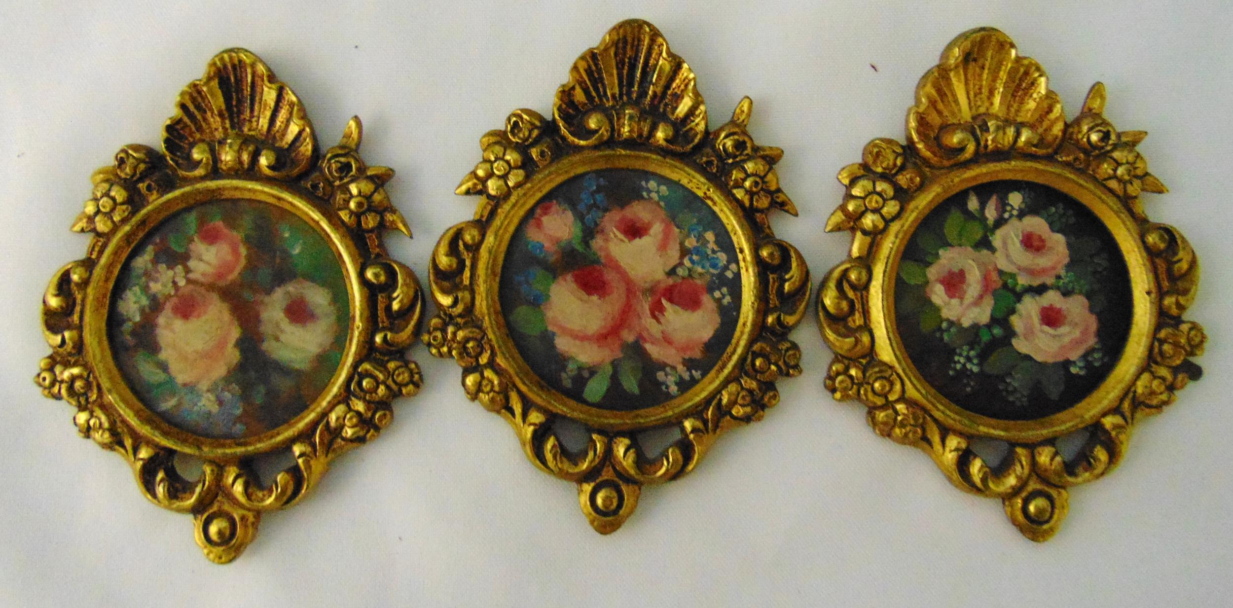 Three gilt metal wall plaques decorated with flowers and leaves, each 11x 8cm