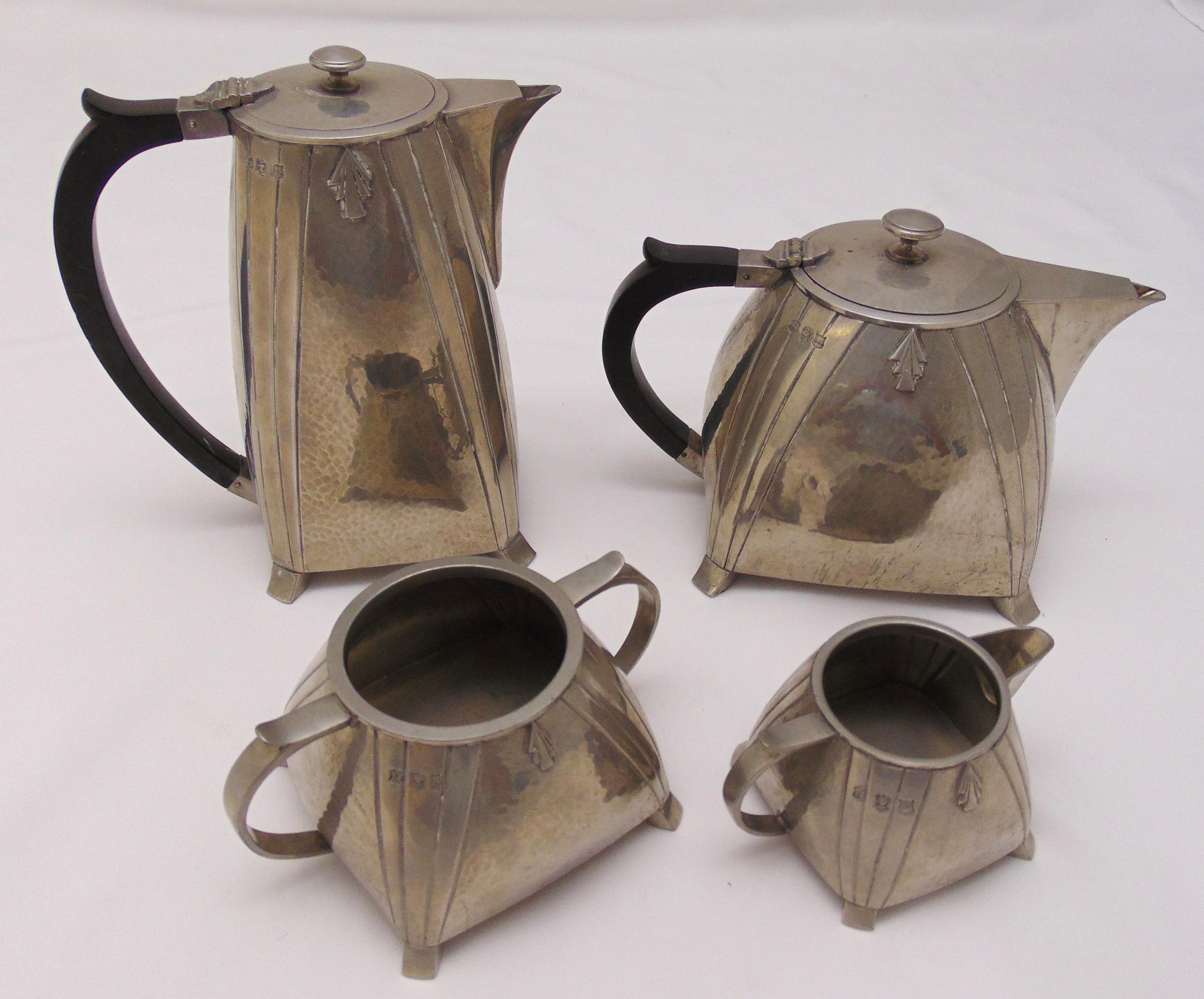 A hand hammered Arts and Crafts pewter teaset of tapering rectangular form with applied geometric