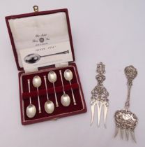 A hallmarked silver cased set of Queen Anne style coffee spoons and two Dutch white metal decorative