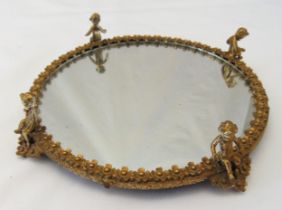 A circular gilt metal mirror plateau with applied putti, 19.5cm (dia)