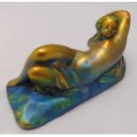 A continental ceramic figurine of a recumbent lady on rectangular plinth, marks to the base, 10 x