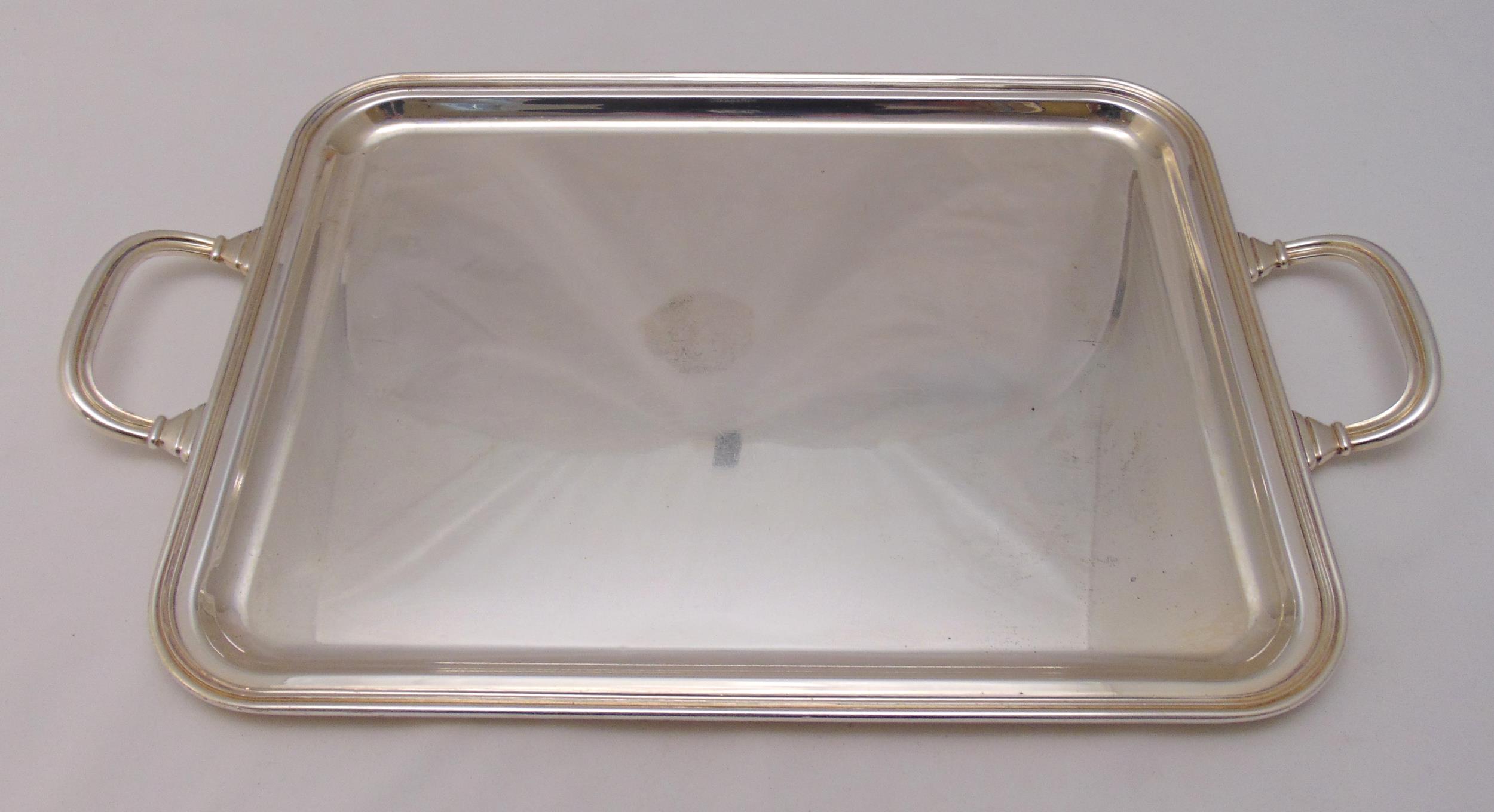A continental white metal rectangular tea tray with moulded borders and pierced scroll handles,