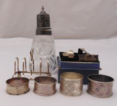 A quantity of hallmarked silver to include a toast rack, four napkin rings, a cut glass sugar shaker