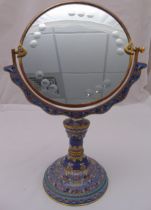 A gilded metal and champlevé dressing table mirror, the raised circular base decorated with stylised