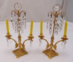 A pair of gilt metal two branch candelabra with glass drop lustres on raised circular bases, 32cm (