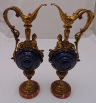 A pair of gilt metal and ceramic decorative flagons of classical form with circular bodies on raised