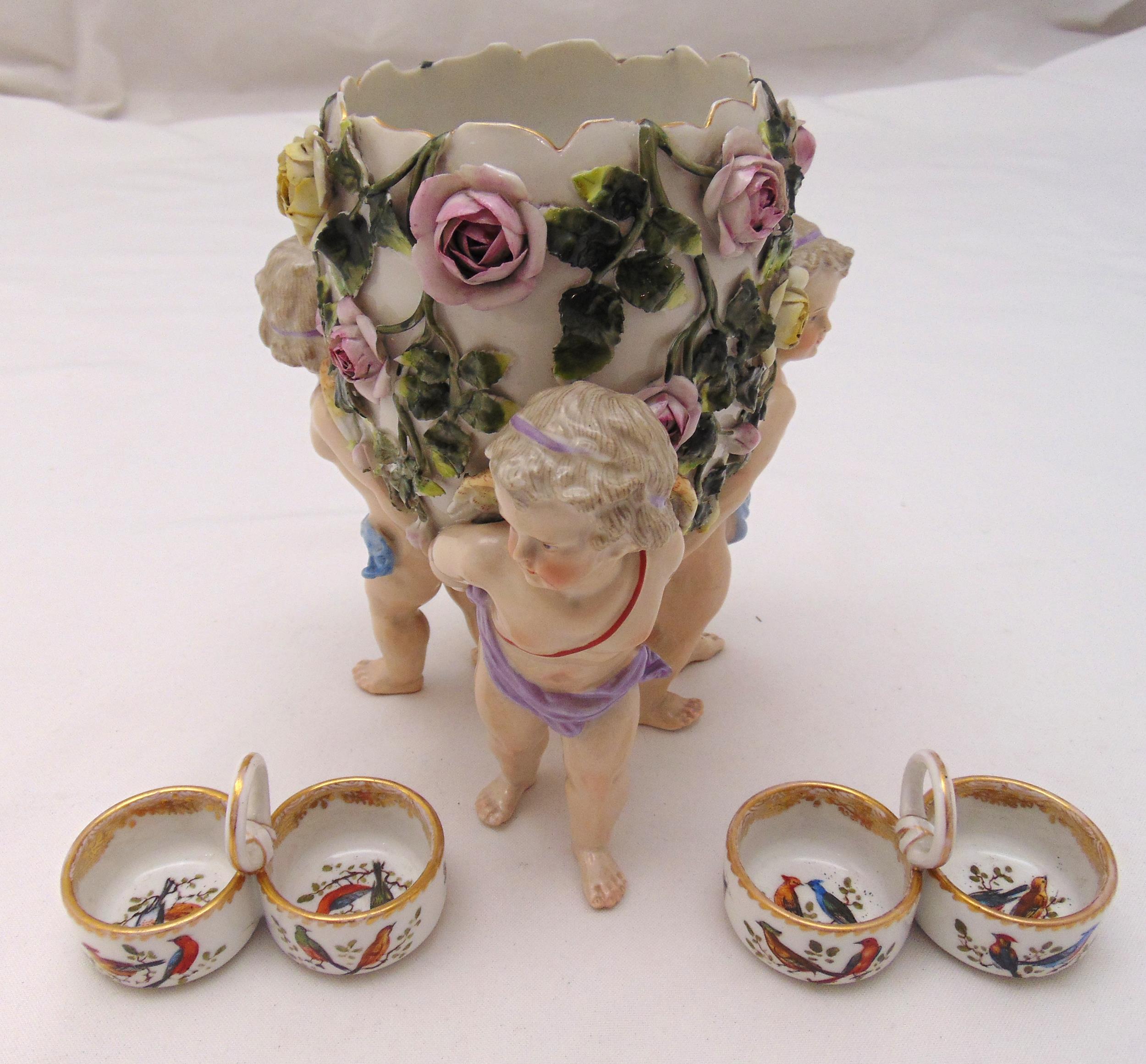 A pair of Meissen salts and a Sitzendorf pot pourri holder in the form of putti holding a basket