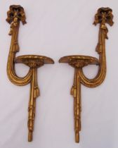 A pair of gilded wooden wall mounted shelves in the form of a sash with ribbon finials, 58 x 21 x